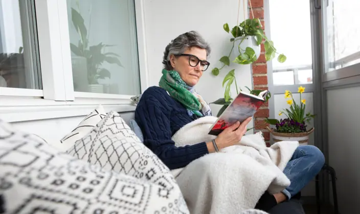 Kvinna läser på balkongen